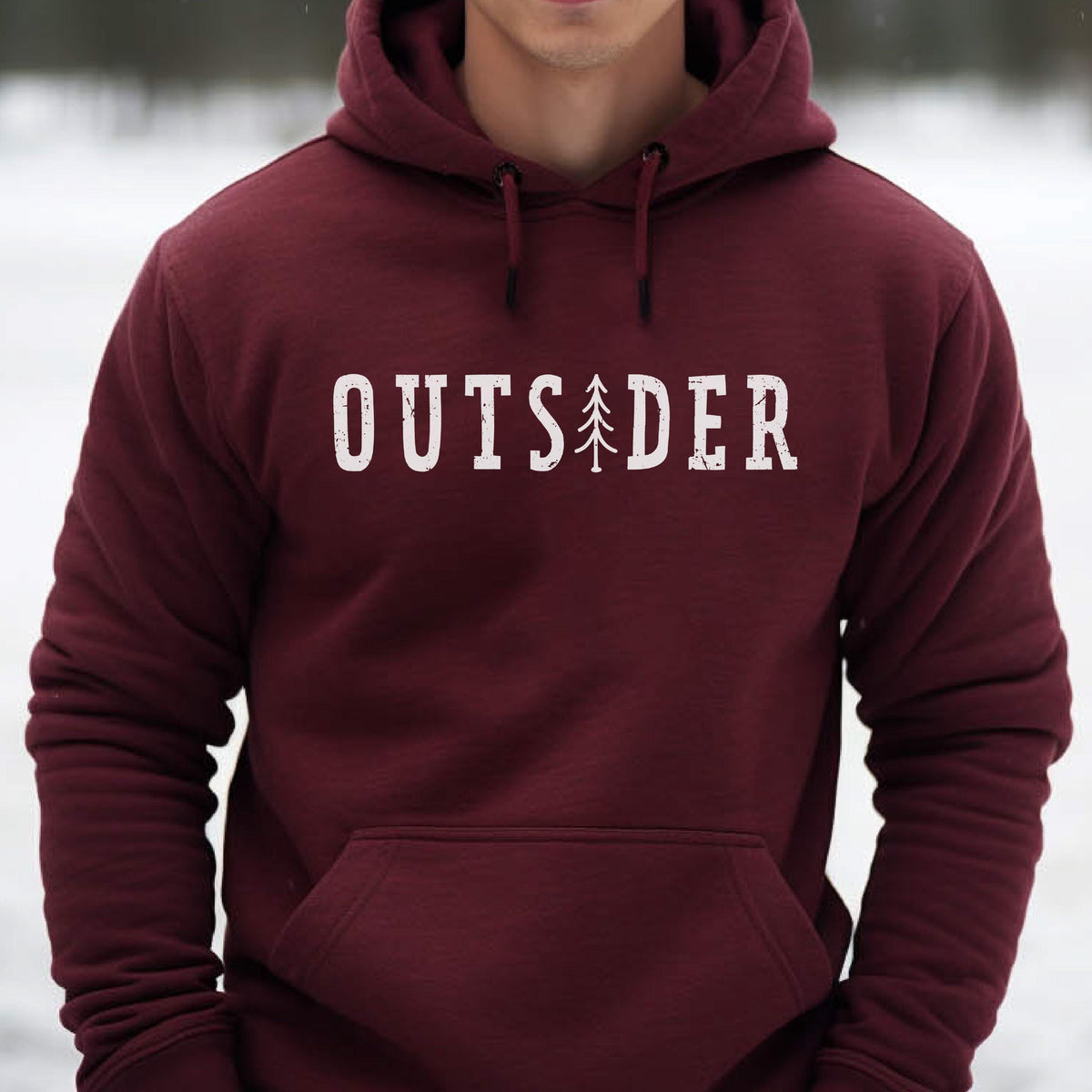 May include: A maroon hooded sweatshirt featuring a white distressed graphic on the chest that reads OUTSIDER, with a stylized pine tree replacing the letter I. The garment includes a front kangaroo pocket and matching maroon drawstrings.