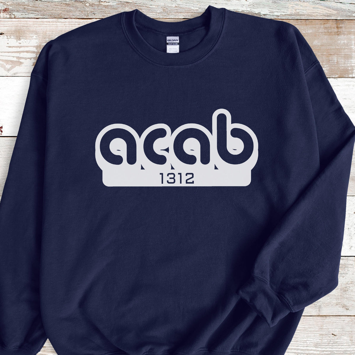 May include: A navy blue sweatshirt with a white graphic of the text "ACAB" in a stylized font with the number "1312" underneath.
