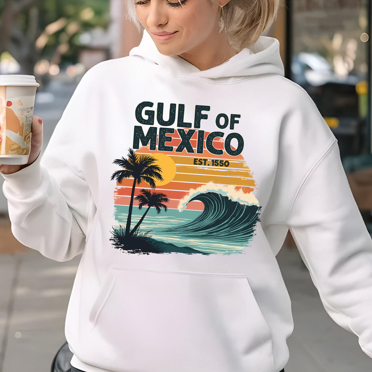 May include: White hoodie with a retro-style graphic design featuring a palm tree, sunset, and wave. The text "GULF OF MEXICO EST. 1550" is printed on the hoodie.