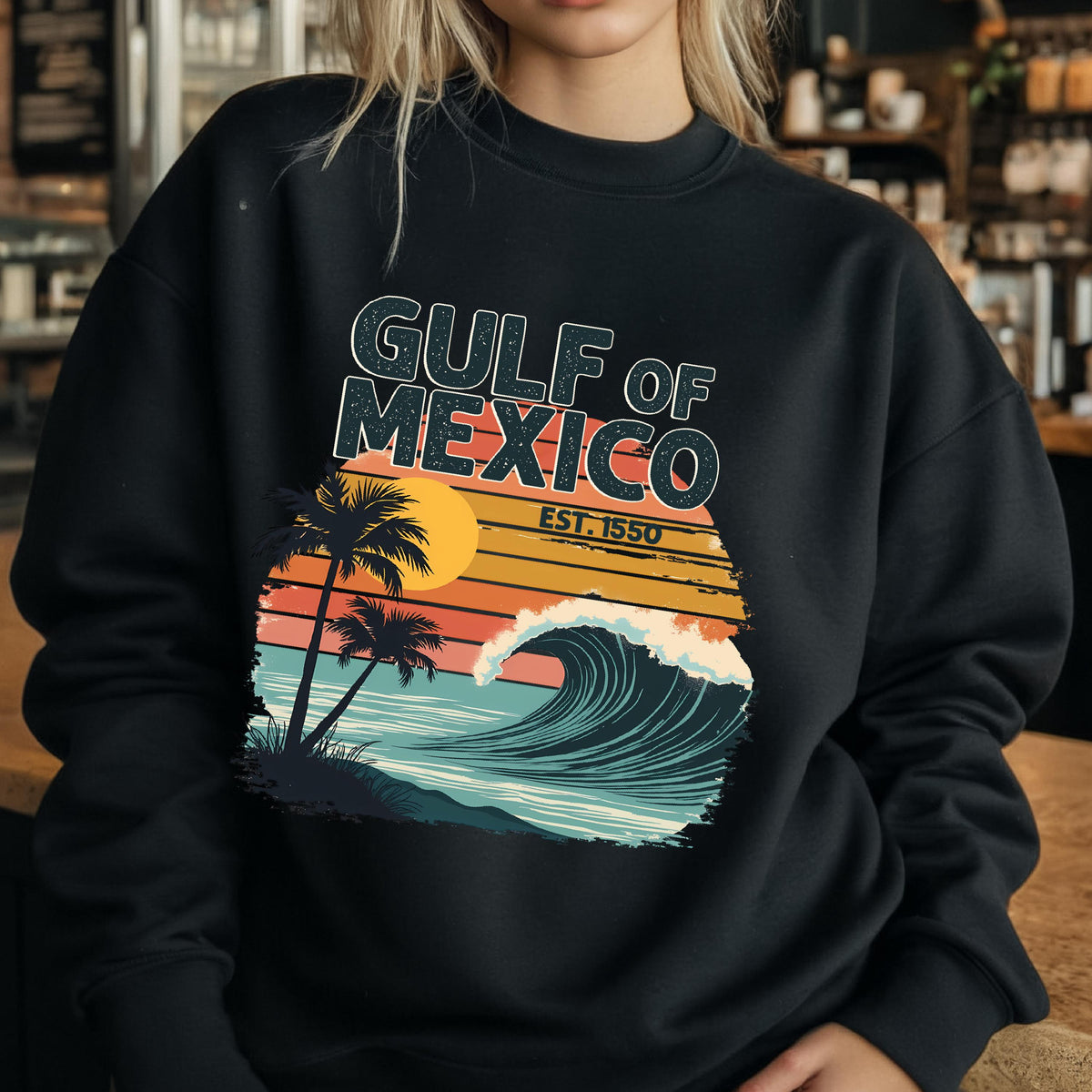 May include: Black sweatshirt with a retro-style graphic design featuring a wave, palm trees, and the text "GULF OF MEXICO EST. 1550".