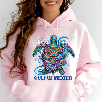 May include: Pink hooded sweatshirt featuring a colorful sea turtle design. The turtle has a patterned shell with floral and geometric elements, surrounded by blue water swirls. The text "GULF OF MEXICO" is printed below the turtle.
