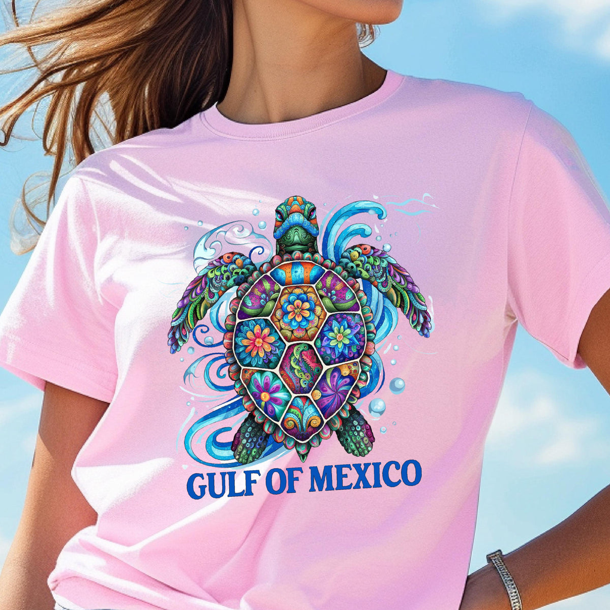 May include: Pink t-shirt with a colorful, detailed sea turtle design and the text "GULF OF MEXICO" in blue.
