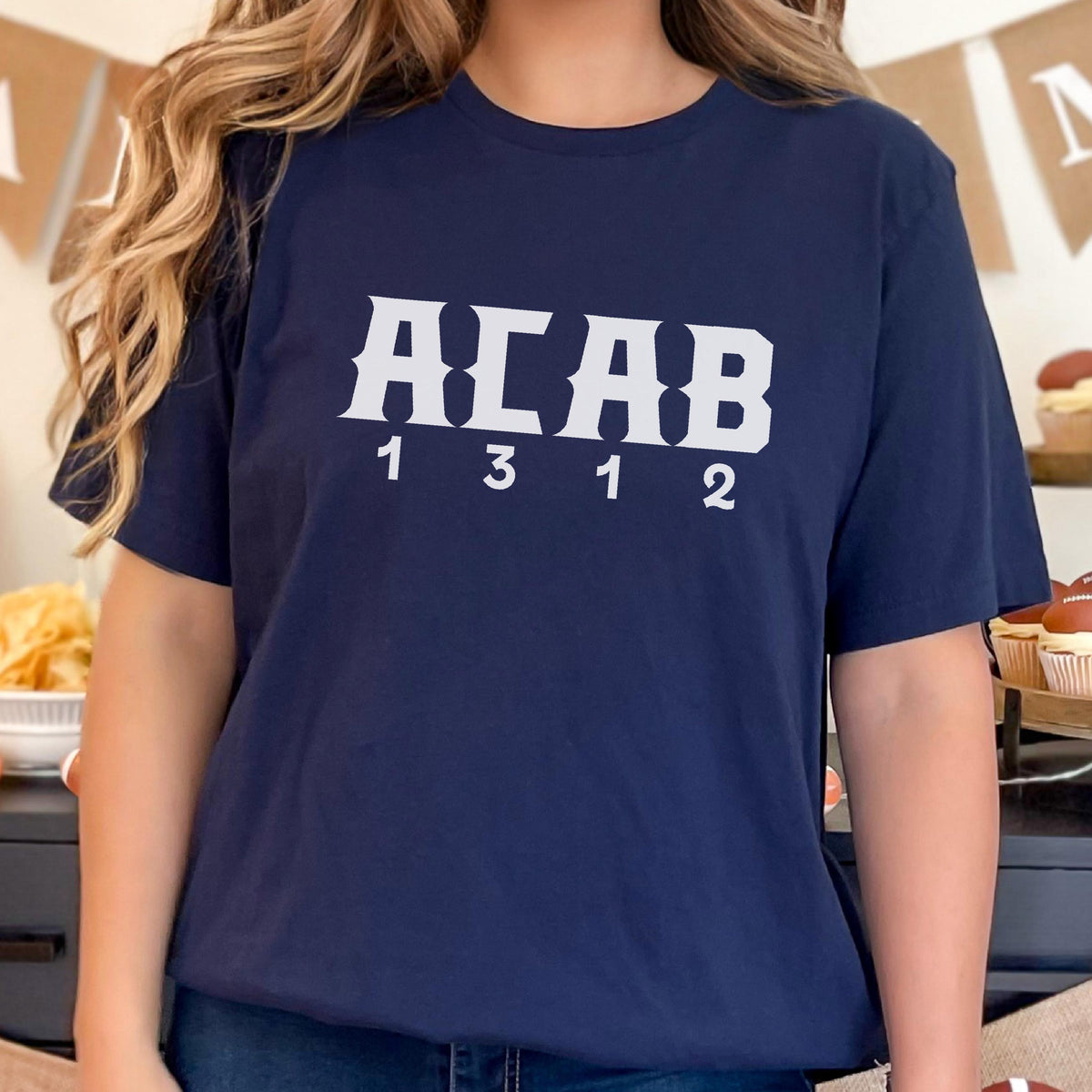 May include: A navy blue t-shirt with white text that reads "ACAB 1312".