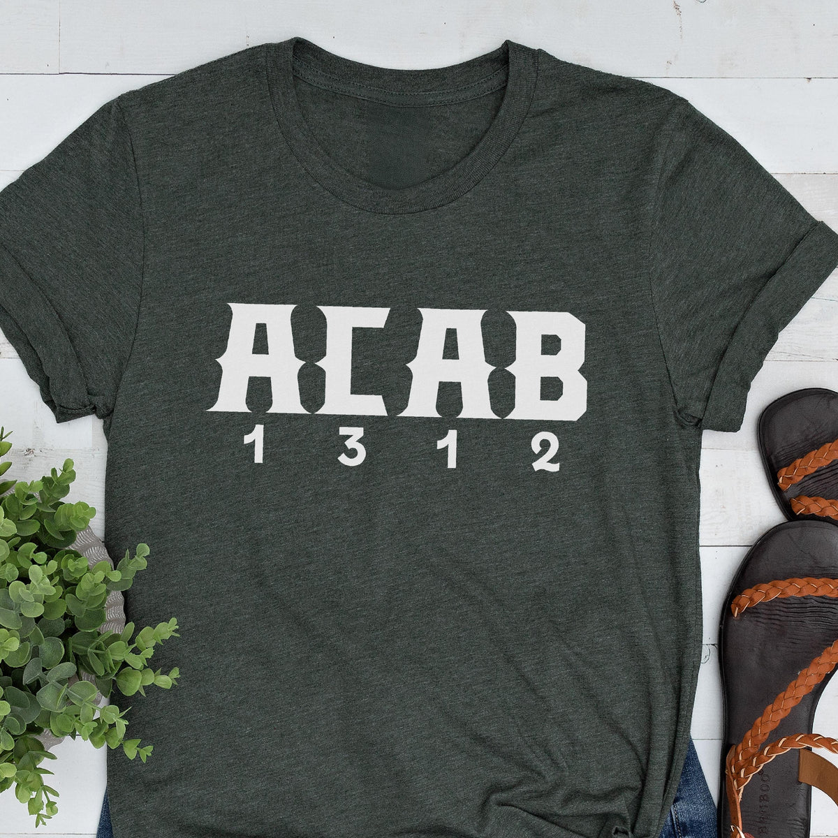 May include: A dark green t-shirt with white text that reads "ACAB 1 3 1 2".