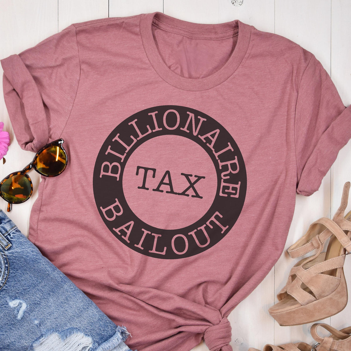 May include: A pink t-shirt with a black circle graphic that says "Billionaire Tax Bailout".