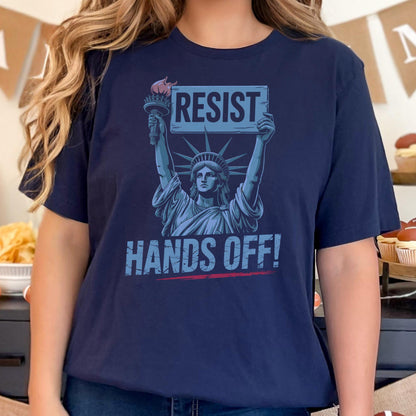 May include: A navy blue t-shirt with a graphic of the Statue of Liberty holding a sign that says "Resist" and the text "Hands Off!" underneath.
