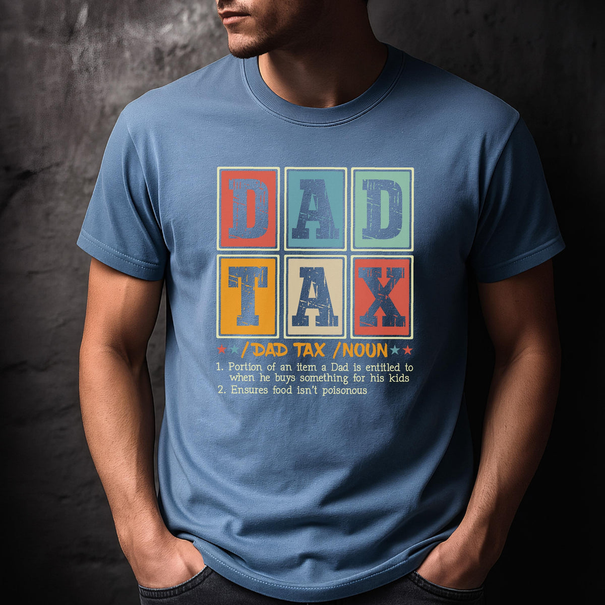 May include: A light blue t-shirt with the words "DAD TAX" in a colorful, block-letter design. Below the text is a definition of "DAD TAX" and its purpose. The shirt is a humorous gift idea.