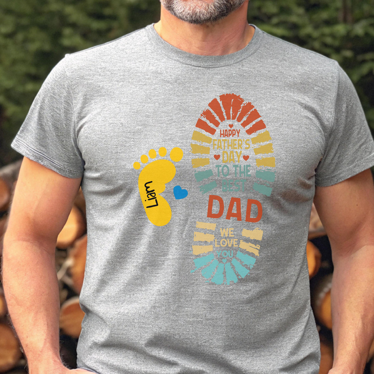 May include: A gray t-shirt with a colorful graphic design for Father's Day. The design includes a footprint, a baby footprint, and the text "Happy Father's Day to the best Dad, we love you."