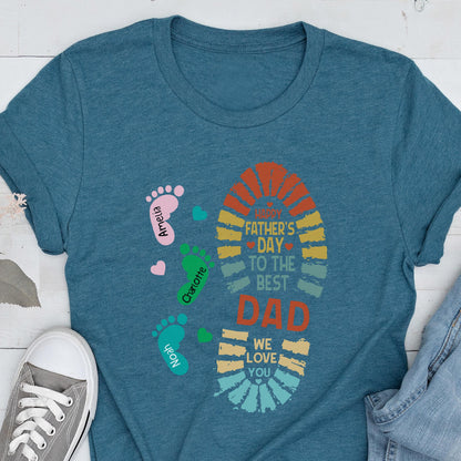 May include: Teal t-shirt with a colorful Father's Day design. The design includes a footprint shape with the text "Happy Father's Day to the Best Dad, We Love You." Footprints with names Amelia, Charlotte, and Noah are also featured.