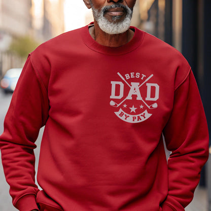 May include: A red sweatshirt with the text "BEST DAD BY PAY" in white. The design includes crossed golf clubs and stars. The sweatshirt is a solid color and has a crew neck.