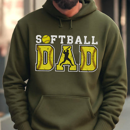 May include: Olive green hoodie with the text "SOFTBALL DAD" in white and yellow. The word "DAD" is designed with a softball graphic and a silhouette of a batter. The hoodie has a front pocket and a hood.