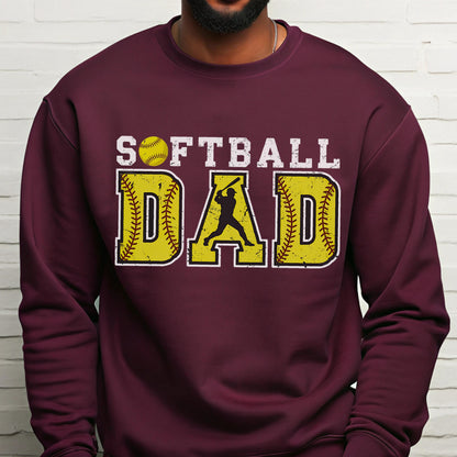 May include: Burgundy sweatshirt with the words "SOFTBALL DAD" in white and yellow. The word "DAD" is designed with a softball and a batter silhouette. The sweatshirt is a solid burgundy color.