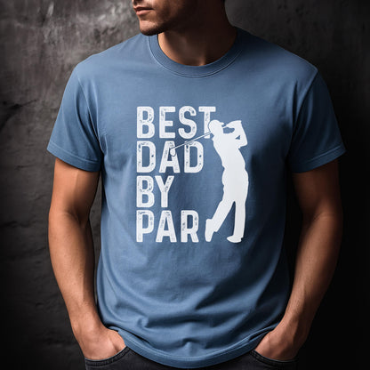 May include: A dusty blue short-sleeved t-shirt featuring a white graphic print. The design includes the text "BEST DAD BY PAR" in a distressed font, accompanied by a white silhouette of a golfer mid-swing with a golf club.