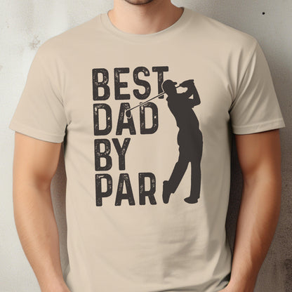 May include: A beige short-sleeved t-shirt featuring a dark brown graphic of a golfer in mid-swing. To the left of the golfer, the text reads "BEST DAD BY PAR" in a bold, distressed, sans-serif font. The design is centered on the chest.