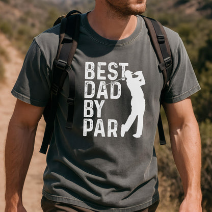 May include: A charcoal gray short-sleeve t-shirt featuring a white graphic print of a golfer in mid-swing. The text "BEST DAD BY PAR" is printed in a distressed white font to the left of the golfer silhouette. The shirt has a crew neckline.