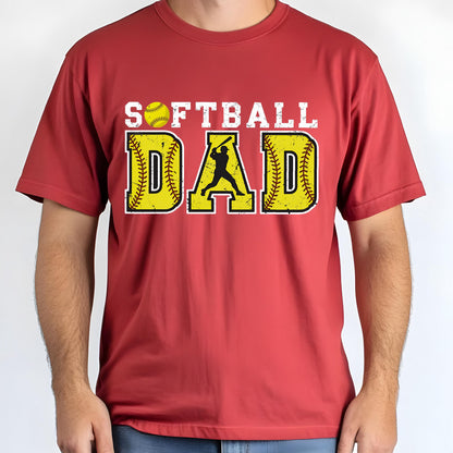 May include: Red t-shirt with a distressed white graphic that says "Softball Dad" with a softball and a silhouette of a player hitting a ball.