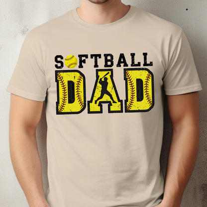 May include: A beige t-shirt with a distressed graphic design that says "Softball Dad" with a softball and a silhouette of a baseball player.