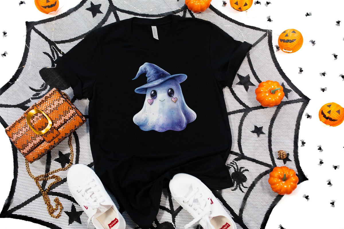 May include: Black t-shirt featuring a watercolor illustration of a friendly ghost wearing a blue witch hat. The ghost has heart-shaped cheeks. The shirt is styled with white sneakers, an orange purse, and Halloween decorations.
