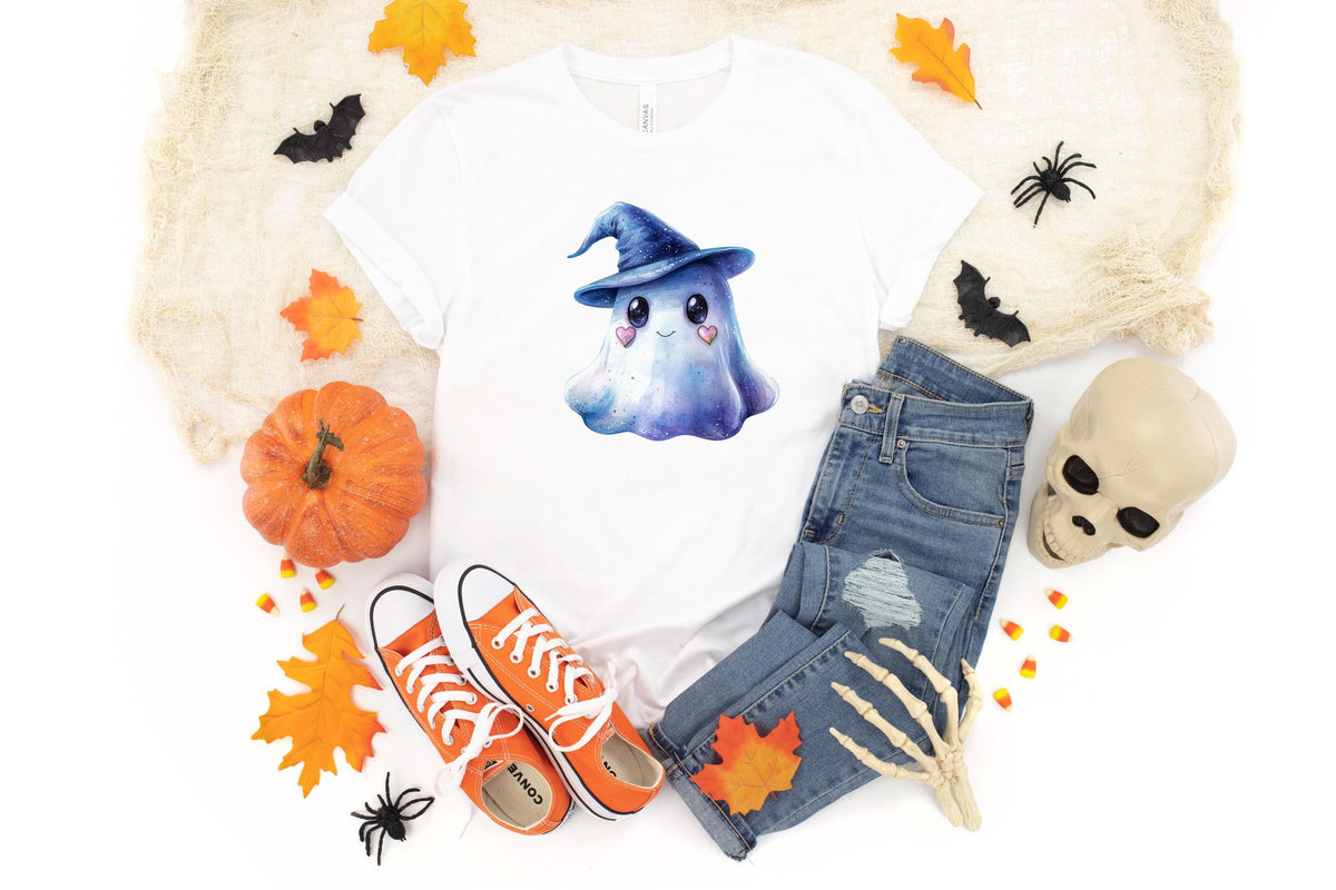 May include: White t-shirt featuring a watercolor illustration of a cute ghost wearing a blue witch hat. The image includes orange sneakers, blue jeans, a pumpkin, and Halloween decorations, perfect for the spooky season.