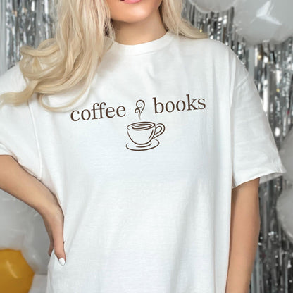 May include: A white short-sleeved t-shirt featuring the brown text coffee books with a small brown graphic of a steaming coffee cup centered between the two words. The shirt has a crew neckline and a standard fit, made of a solid white fabric.