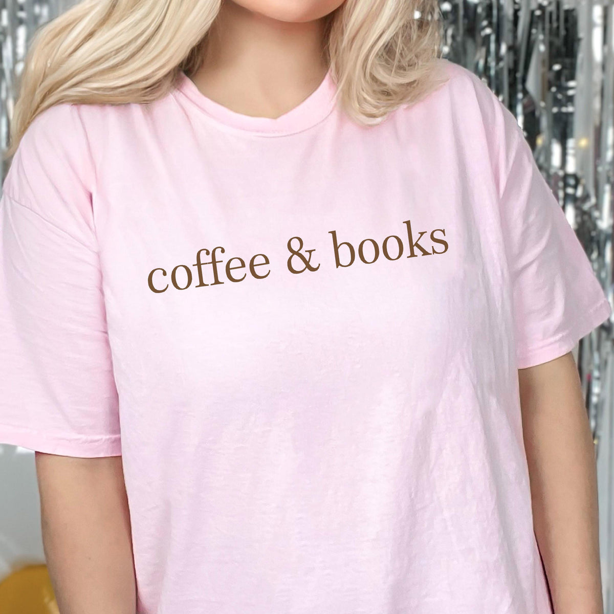 May include: A pink t-shirt with the text "coffee & books" printed in brown on the front.