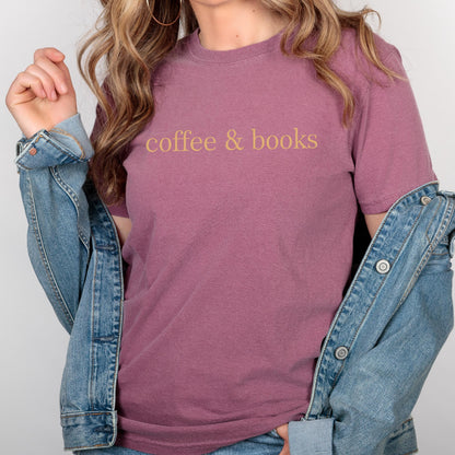 May include: A mauve colored t-shirt with the text "coffee & books" in a light yellow color.