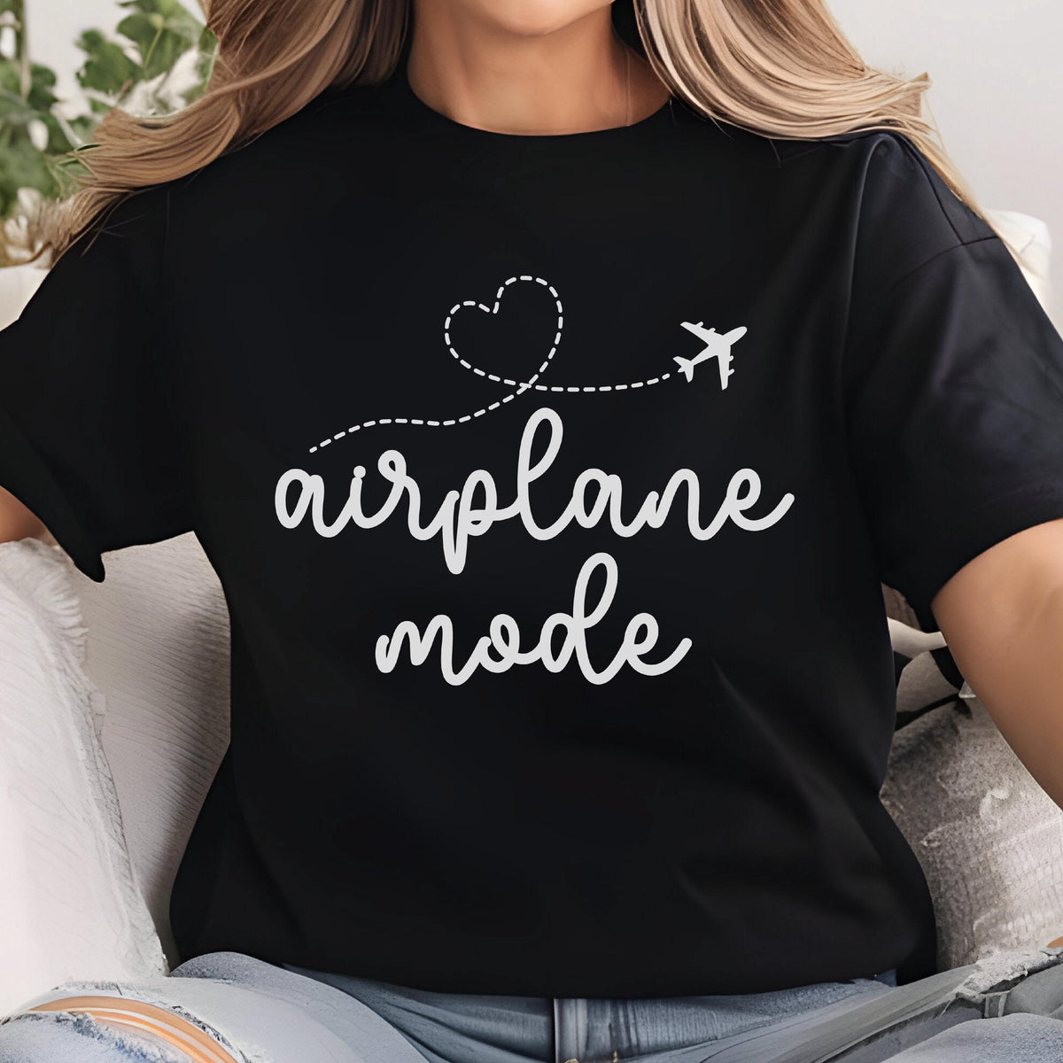 May include: Black t-shirt with the words "airplane mode" in a white, cursive font. A dotted line with a heart and airplane graphic is above the text. The shirt is a casual style.