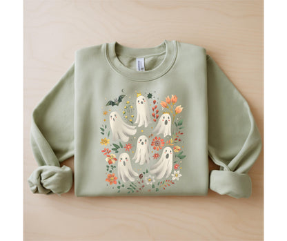May include: Sage green sweatshirt featuring a whimsical design of friendly ghosts surrounded by colorful flowers, leaves, and a bat. The ghosts have smiling faces and are adorned with small crowns. A charming and festive garment for Halloween.