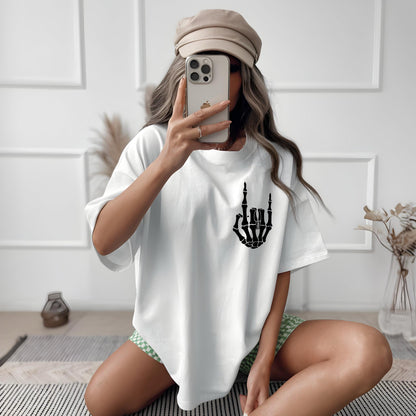 May include: White oversized t-shirt with a black skeleton hand graphic making the rock and roll hand gesture.