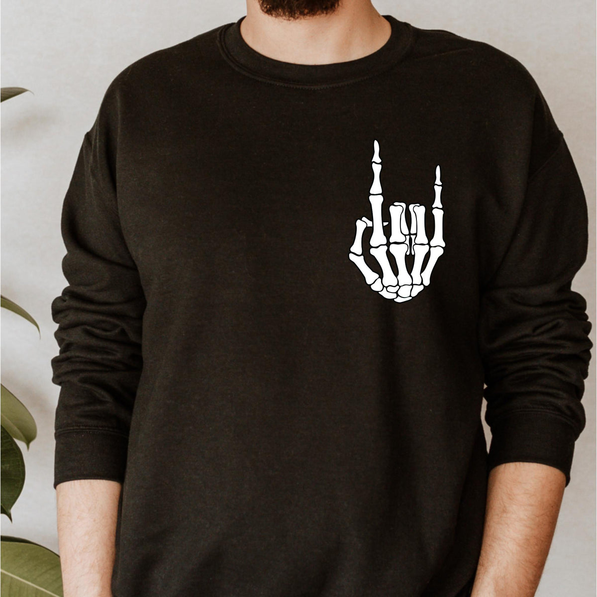 May include: Black long-sleeved sweatshirt with a white skeleton hand making a rock and roll hand gesture.