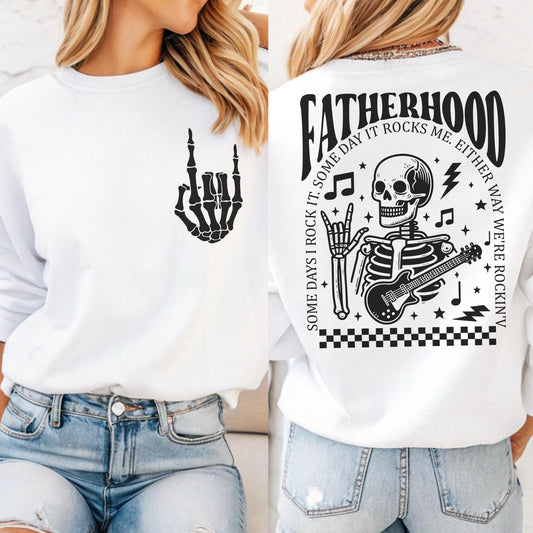 May include: White sweatshirt with a black skeleton playing a guitar and the text "Fatherhood Some Days I Rock It. Some Day It Rocks Me. Either Way We're Rockin'" on the back. The front of the sweatshirt has a black skeleton hand making a rock and roll sign.