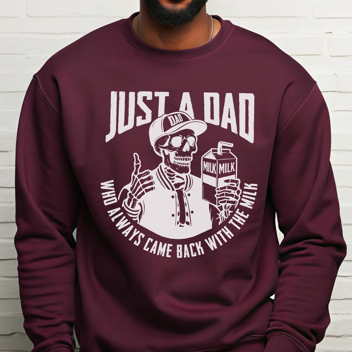 May include: Burgundy sweatshirt with a white graphic of a skeleton wearing a baseball cap that says "DAD" and holding a milk carton. The text reads "JUST A DAD WHO ALWAYS CAME BACK WITH THE MILK."