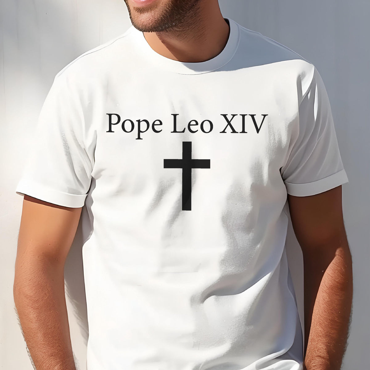 May include: White t-shirt with the text "Pope Leo XIV" above a black cross. The shirt has short sleeves and a crew neck. The design is centered on the chest.