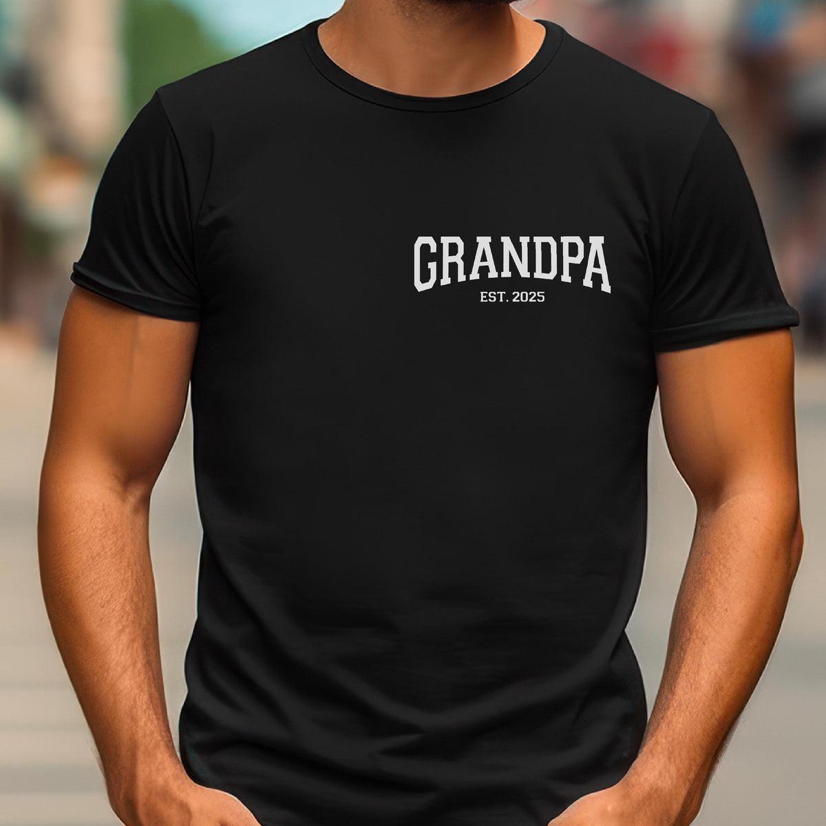 May include: Black t-shirt with the word "GRANDPA" in white, arched text. Below the word "GRANDPA" is the text "EST. 2025". The t-shirt is a crew neck style.
