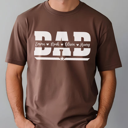 May include: A brown t-shirt with the word "DAD" in large white block letters. Below the word "DAD" are the names Emma, Noah, Olivia, and Henry, each separated by a heart symbol. A white star is centered below the names.