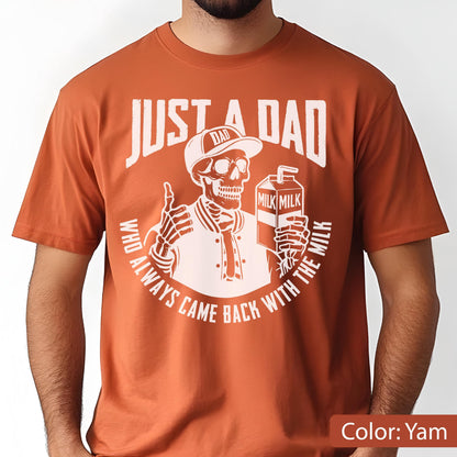 May include: A yam-colored t-shirt features a white graphic of a skeleton wearing a baseball cap and jacket, holding a milk carton and giving a thumbs-up. The text reads "JUST A DAD" and "WHO ALWAYS CAME BACK WITH THE MILK."