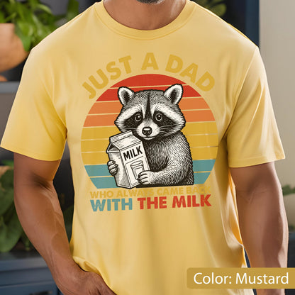 May include: Mustard yellow t-shirt featuring a raccoon holding a milk carton. The design includes the text "JUST A DAD WHO ALWAYS CAME BACK WITH THE MILK" in a retro sunset style.