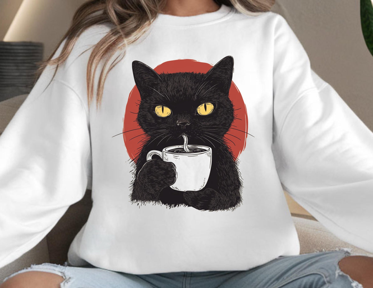 May include: A white long-sleeve sweatshirt featuring a graphic illustration of a black cat with bright yellow eyes holding a white coffee mug. Behind the cat is a solid red circle. The cat is depicted drinking from the mug with a straw.