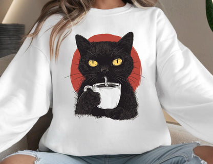 May include: A white long-sleeve sweatshirt featuring a graphic illustration of a black cat with bright yellow eyes holding a white coffee mug. Behind the cat is a solid red circle. The cat is depicted drinking from the mug with a straw.