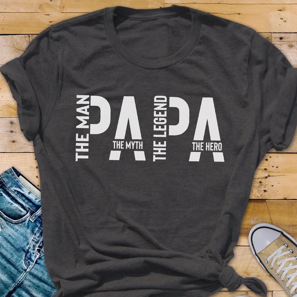 May include: Dark gray t-shirt with the word "PAPA" in large white letters. The words "The Man," "The Myth," "The Legend," and "The Hero" are also printed on the shirt in white.