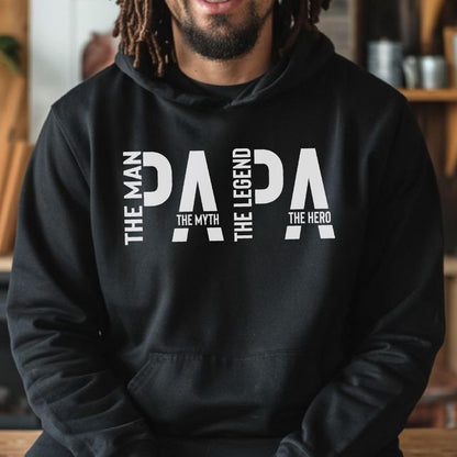 May include: Black hooded sweatshirt with the word "PAPA" in large white letters. The text "THE MAN", "THE MYTH", "THE LEGEND", and "THE HERO" are vertically aligned on the left and right sides of the word "PAPA".