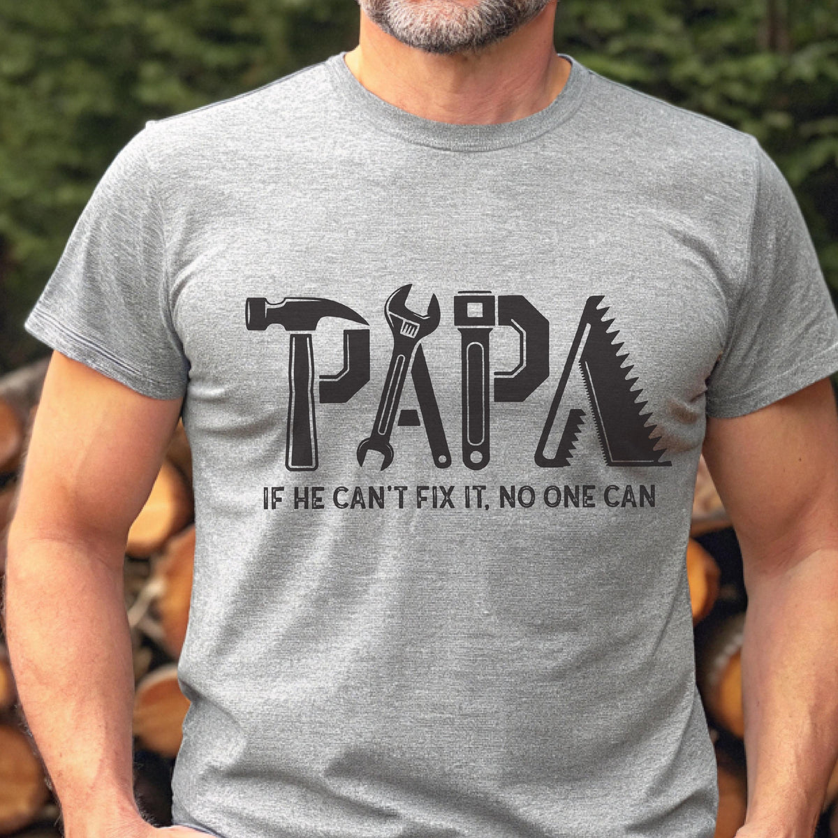 May include: A gray t-shirt with the word "PAPA" in black, designed with tools like a hammer, wrench, and saw. The text "IF HE CAN'T FIX IT, NO ONE CAN" is below the word "PAPA".