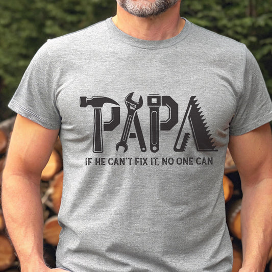 May include: A gray t-shirt with the word "PAPA" in black, designed with tools like a hammer, wrench, and saw. The text "IF HE CAN'T FIX IT, NO ONE CAN" is below the word "PAPA".