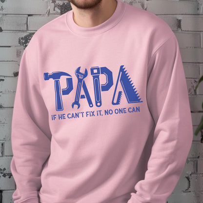 May include: A light pink sweatshirt with the word "PAPA" in blue, with each letter designed as a tool: hammer, wrench, level, and saw. Below the word is the text "IF HE CAN'T FIX IT, NO ONE CAN."