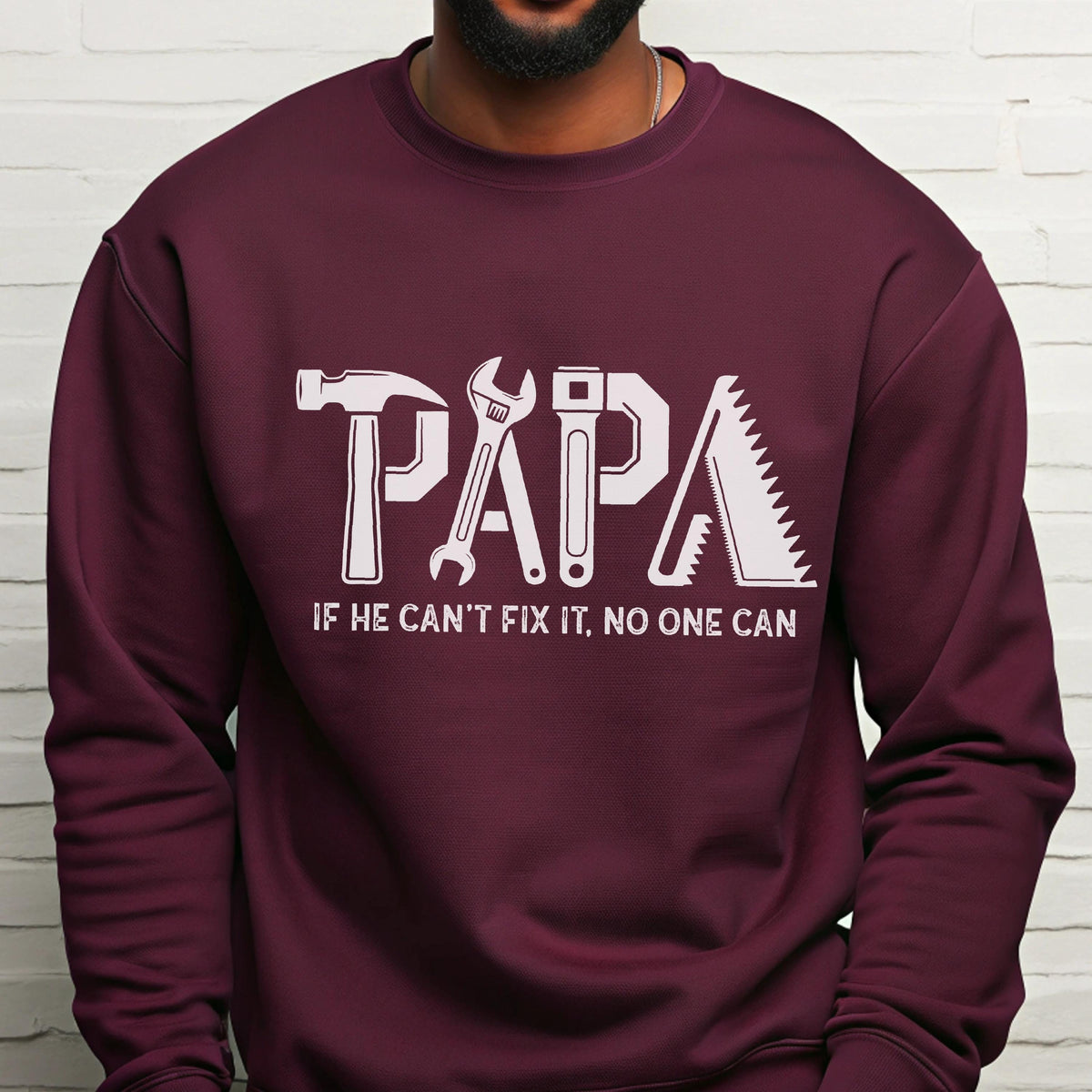 May include: Burgundy sweatshirt with the word "PAPA" in white, formed by tools: a hammer, wrench, adjustable wrench, and saw. Below the word "PAPA" is the text "IF HE CAN'T FIX IT, NO ONE CAN."