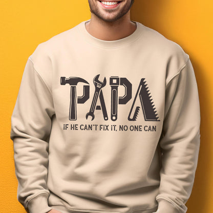 May include: Beige sweatshirt with the word "PAPA" in large, dark gray block letters, each letter designed as a tool: hammer, wrench, screwdriver, and saw. The text "IF HE CAN'T FIX IT, NO ONE CAN" is below.