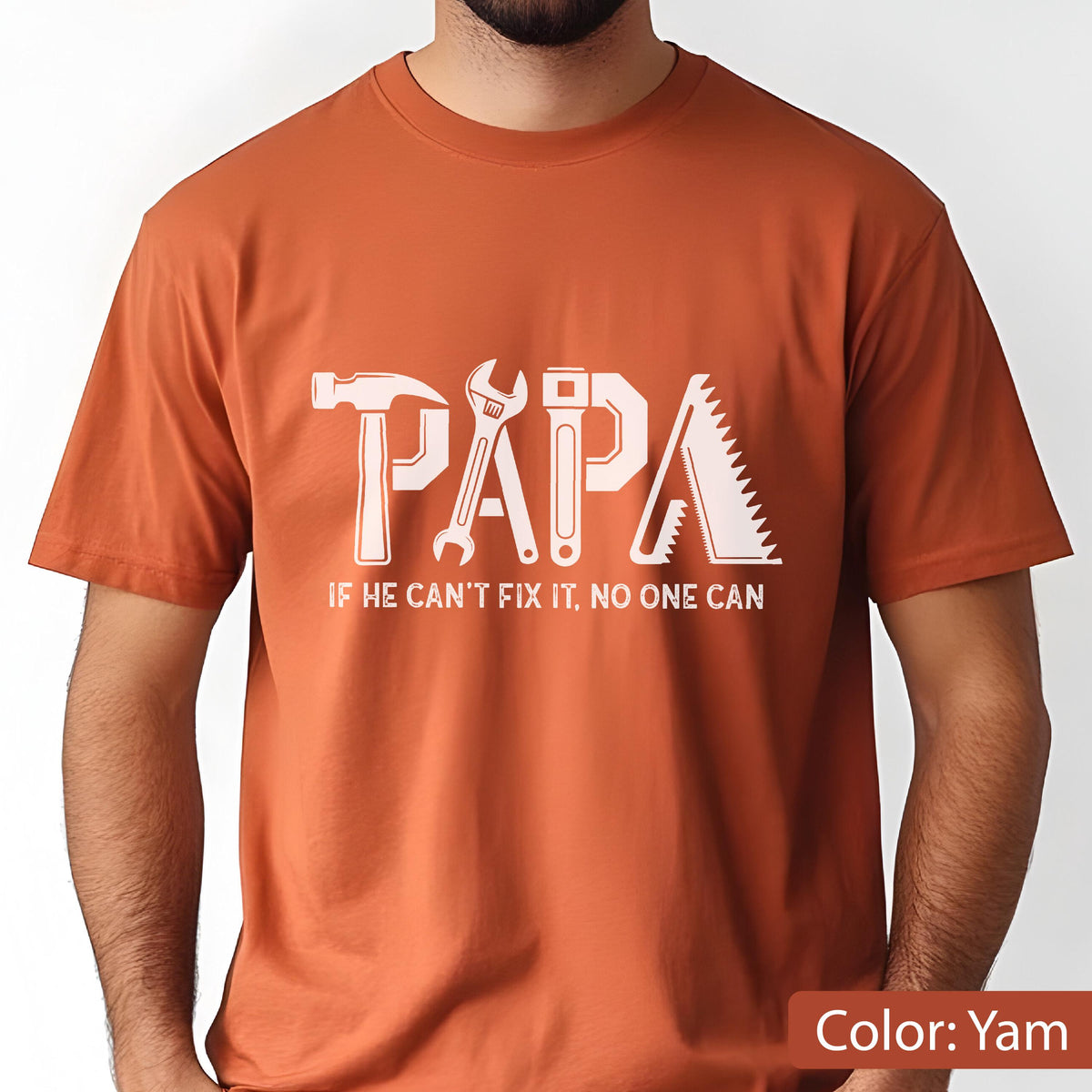 May include: A yam-colored t-shirt with the word "PAPA" in white, designed with tool graphics. Below the word is the text "IF HE CAN'T FIX IT, NO ONE CAN."