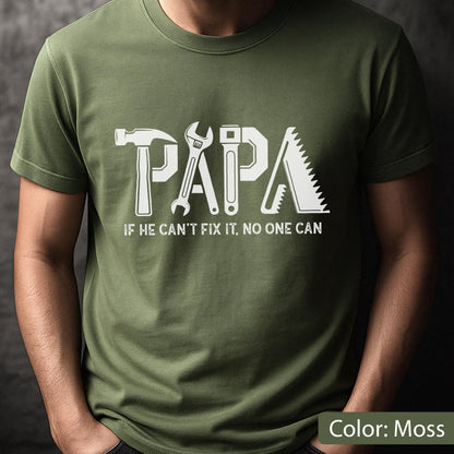 May include: Moss green t-shirt with the word "PAPA" in white, incorporating tool graphics. Below, the text reads "IF HE CAN'T FIX IT, NO ONE CAN." The shirt is a solid color and has short sleeves.