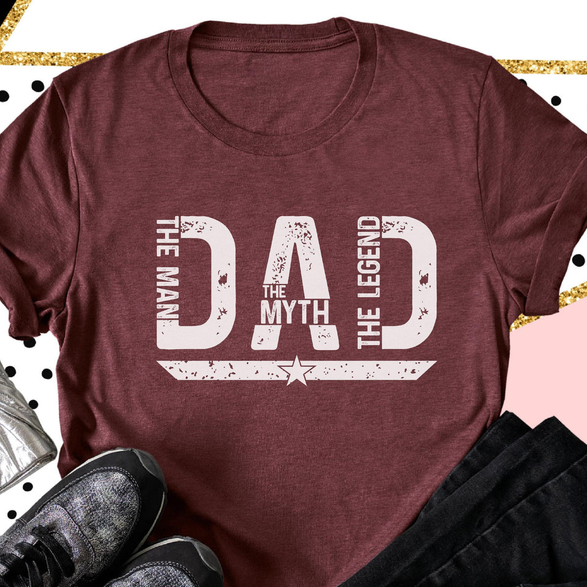 May include: Maroon t-shirt with the text "DAD THE MAN THE MYTH THE LEGEND" in distressed white lettering. The design includes a star and a horizontal line. The shirt is a crew neck.