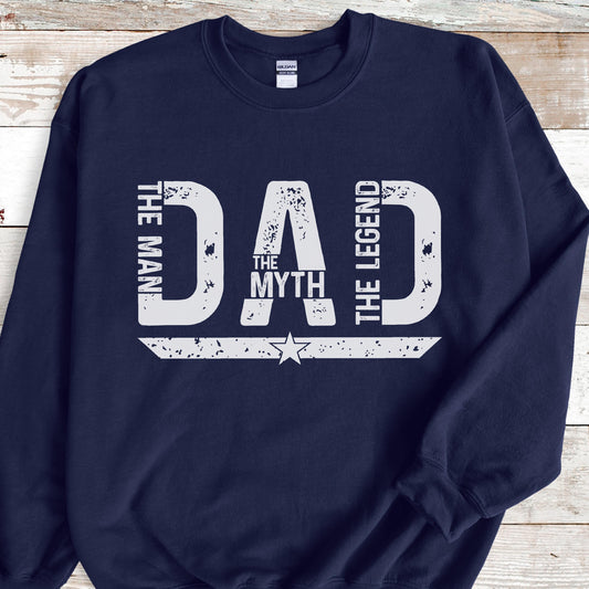 May include: Navy blue sweatshirt with the white text "DAD" in a distressed font. The words "THE MAN" and "THE LEGEND" flank the sides of the word "DAD". The word "THE MYTH" is centered below the "A". A white star is below the text.